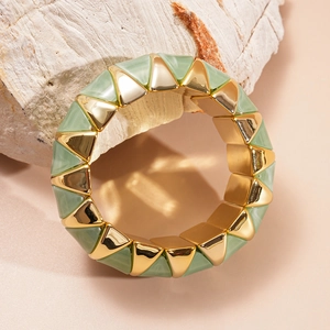 Close-up of geometric acrylic bangle with green marble texture and gold metal details