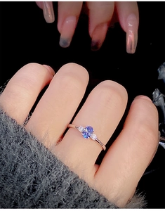 Close-up of s925 silver ring featuring oval violet zircon with side stones on hand