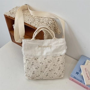 Detailed macro view of pastoral floral canvas bag with white lace trim and embroidery