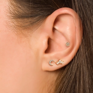Detail view of gold S925 silver stud earrings with moon and crown diamond shapes