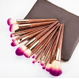 Detail of 14 professional wooden makeup brushes with purple bristles in a brown PU leather case