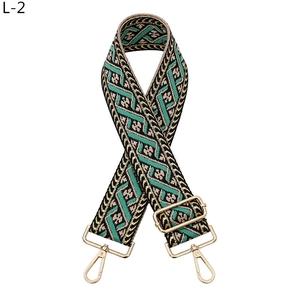 Close-up of ethnic jacquard purse strap with geometric patterns and gold metal hooks
