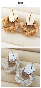 Detail of vintage 18K gold and silver plated woven mesh knot earrings on velvet