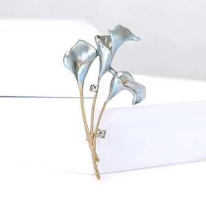 Detail of elegant gold lily brooch with blue enamel petals and sparkling crystals