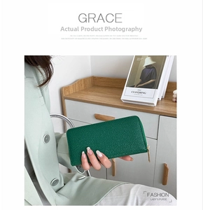 Detail of green pebbled leather wallet featuring high-quality gold zipper and texture
