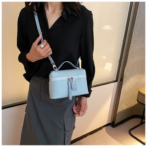 Light blue faux leather mini bucket bag with silver hardware on a model outfit