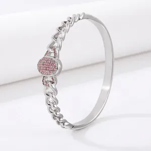 Detail view of silver stainless steel cuff with Cuban chain and pink zircon pavé oval charm