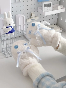 Detail of plush mittens with blue bow, pearl chain and lace accents in ice blue