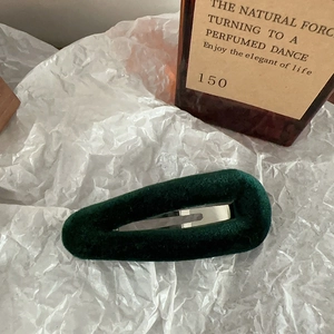 Detail of dark green velvet teardrop hair clip with silver metal snap closure