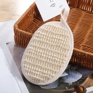 Natuurlijke loofah exfoliërende pad met geweven rand en ophanglus in gevlochten mand
