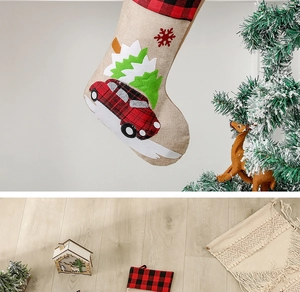 Detail of burlap Christmas stocking featuring a red car and tree embroidery pattern