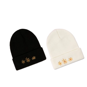 Fashionable ribbed knit beanies in black and white with gold floral embroidery
