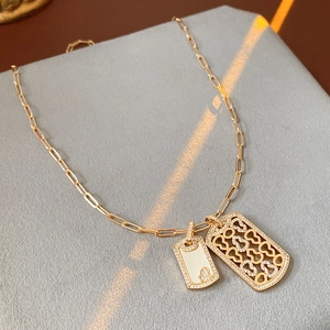 Details einer goldenen Gliederkette mit Zirkonia Herz und Muschel Anhänger
