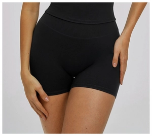 Close-up of high-waisted black yoga shorts showing elastic fabric and tummy control fit