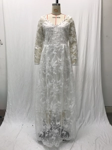 Macro shot of white lace embroidery and sheer mesh sleeves on a bridal gown