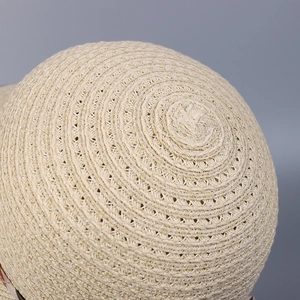 Detailed close-up of woven straw sun hat showing high-quality concentric stitching pattern
