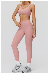 Détail d'ensemble yoga rose brossé avec brassière de sport et legging taille haute