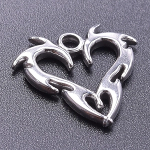 Macro shot of silver stainless steel heart pendant with tribal style pattern for DIY jewelry