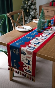 Detailed Christmas table runner with reindeer, jacquard weaving and red fringe tassels