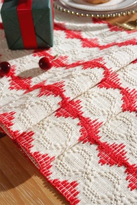Close-up of cotton woven table runner with red geometric textures and tassels