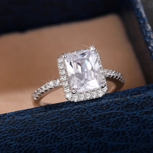 Close-up of rectangle-cut zircon engagement ring with halo setting in a jewelry box