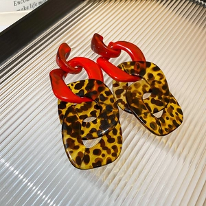 Detailed close-up of retro leopard print resin chain earrings with red links