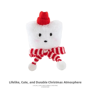 Close-up of a white plush bear with red knitted hat and striped scarf for Christmas