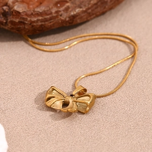Macro shot of gold butterfly pendant necklace on a sleek 18K gold snake chain