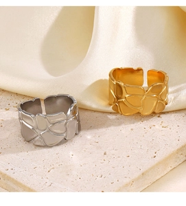 Details von gold- und silberfarbenen Ringen mit geometrischer Textur auf einem Steinsockel
