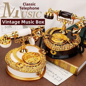 Detail of vintage rotary phone music box featuring golden rose carvings and storage