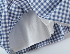 Detailansicht der blau-weiß karierten Stoffstruktur mit weichem Innenfutter und Nähten