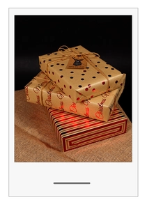 Detail of Christmas gold foil gift wrap with rustic twine and kraft paper tags