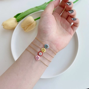 Macro shot of colorful enamel zircon bracelets in pink, red, yellow and blue on wrist