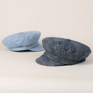 Detail showing denim texture and button top of light and dark blue baker boy hats