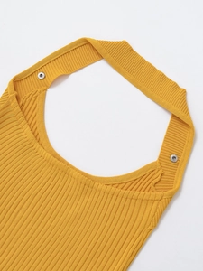 Detailed macro view of yellow ribbed knit fabric and silver metal snap buttons on crop top
