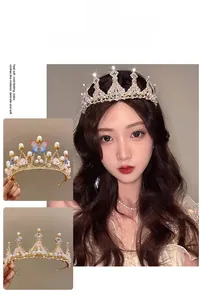 Detailed view of rhinestone crown with gold base, pearls and butterfly accents