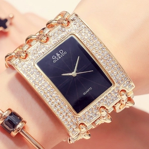 Close-up of a women's gold quartz watch with a black rectangular dial and rhinestones