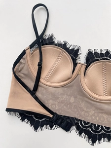 Detail of lace bralette featuring adjustable straps and mesh back closure hook