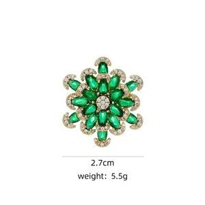 Detailed view of a green gemstone snowflake brooch with 2.7cm diameter and 5.5g weight