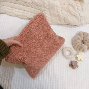 Close-up of pink lamb wool cosmetic bag with soft texture and winter hair accessories
