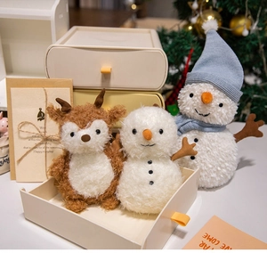 Detail of plush Christmas reindeer and snowman dolls in a cozy festive setting