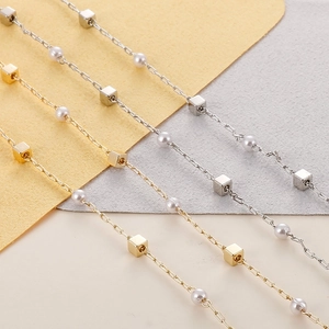 Close-up of titanium steel mask chain with gold and silver cube beads and faux pearls