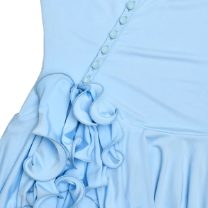 Détail de la robe bleu clair avec boutons ronds et volants superposés élégants