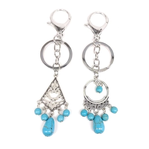 Bohemian turquoise keychain with silver metal pendant and ethnic beads on white background