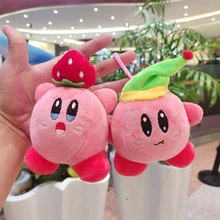 Close-up of cute pink plush Kirby keychains wearing strawberry and green pointed hats