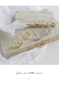 Macro shot of gold and silver irregular spiral geometric earrings on stone