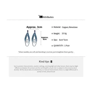 Détails des boucles d'oreilles pompons en strass bleus avec base en cuivre et tige argent