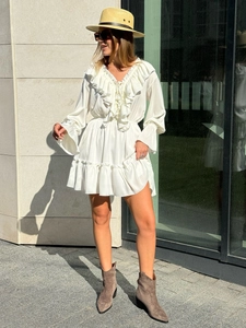 Detail of V-neck white chiffon dress with layered ruffles and flared sleeves
