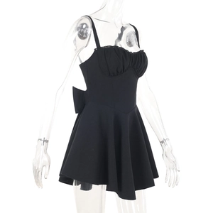 Détail d'une robe courte noire moulante avec un grand nœud au dos et un ourlet à volants élégant