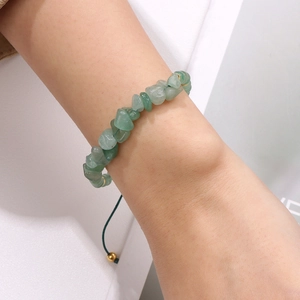 Close-up of natural green stone bead bracelet with adjustable woven strap on wrist